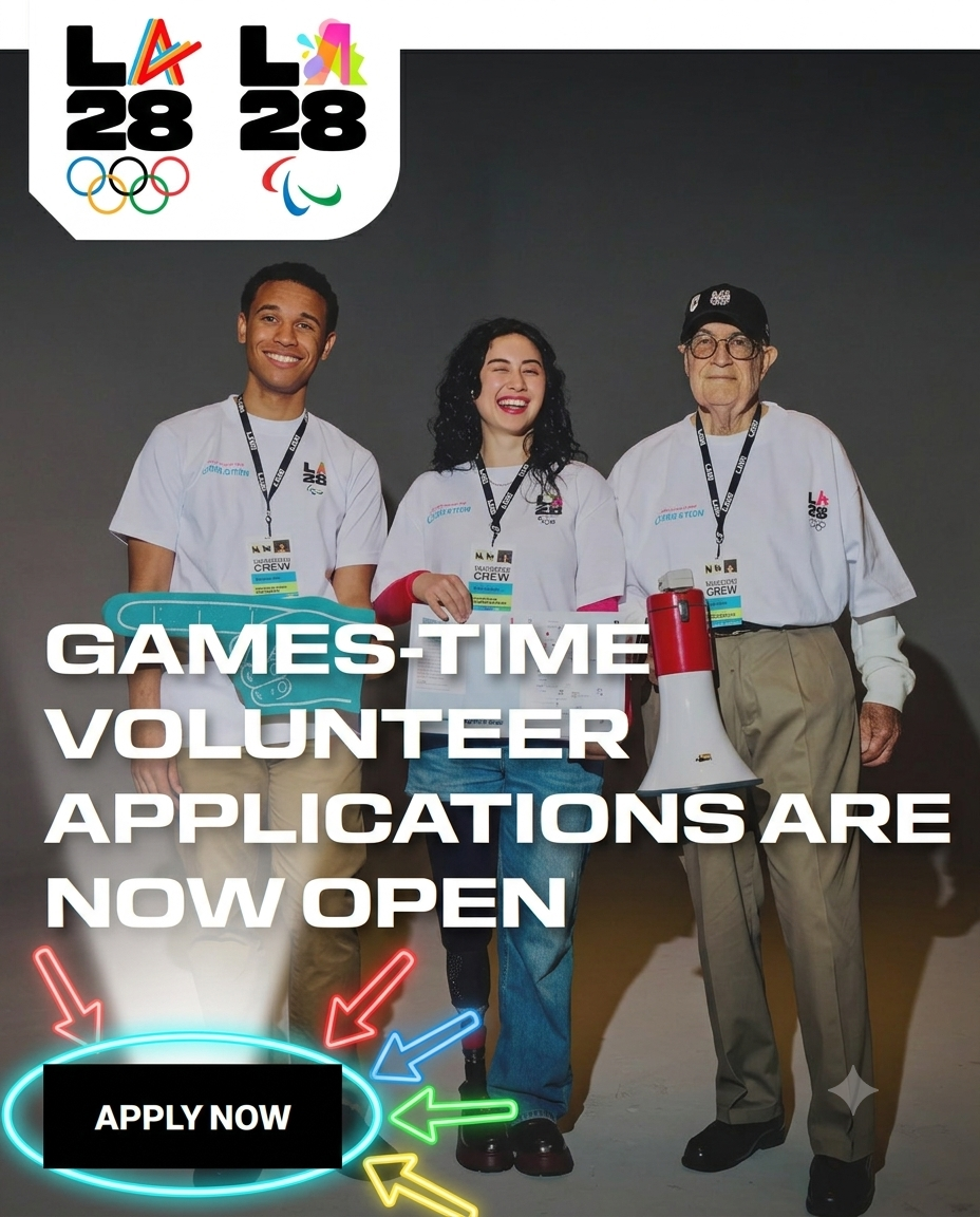 hree diverse volunteers. One (the central winking woman) is using both hands to point down directly toward the text on the t-shirts, which now reads "LA28 VOLUNTEER CREW / GET READY."